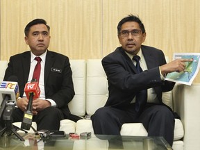 Director general of the Malaysian Department of Civil Aviation, Azharuddin Abdul Rahman, right, shows the search area map during a press conference as Malaysia new Transport Minister Anthony Loke Siew Fook looks on in Putrajaya, Malaysia on Wednesday, May 23, 2018. New Transport Minister Anthony Loke says the search for missing Malaysia Airline Flight 370 ends next Tuesday after a 90-day period under a "no cure no fee" agreement with a private U.S. firm. (AP Photo)