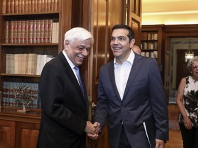 Greek President Prokopis Pavlopoulos, left, welcomes Prime Minister Alexis Tsipras at the presidential palace in Athens, Saturday, on May 19, 2018. Tsipras meets Greek president to brief him about developments in the ongoing efforts to resolve a dispute over neighboring Macedonia's name, which has frustrated the country's aspirations to join NATO and the European Union.