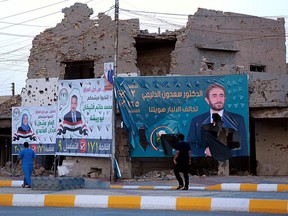 Campaign posters for parliamentary elections are displayed near destroyed buildings from fighting between Iraqi forces and the Islamic State group in Ramadi, 70 miles (115 kilometers) west of Baghdad, Iraq, Friday, May 11, 2018.