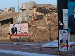 Campaign posters for parliamentary elections are displayed near destroyed buildings from fighting between Iraqi forces and the Islamic State group in Ramadi, 70 miles (115 kilometers) west of Baghdad, Iraq, Friday, May 11, 2018.
