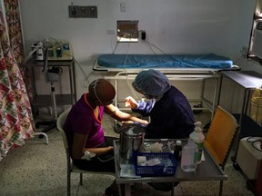 A girl is assisted by a nurse at the chemotherapy room of the "Dr. JM de los Rios" Children's Hospital in Caracas on April 10, 2018.