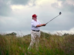 This file photo taken on July 10, 2012 shows Donald Trump playing a stroke as he officially opens his new multi-million pound Trump International Golf Links course in Aberdeenshire, Scotland.