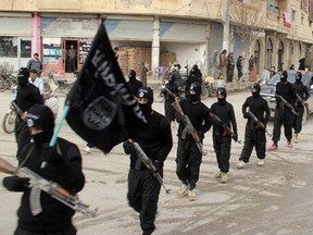 This undated file image posted on a militant website on Tuesday, Jan. 14, 2014 shows fighters from ISIL marching in Raqqa, Syria.