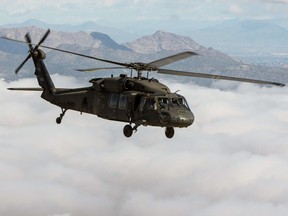 An Arizona Army National Guard UH-60 Black Hawk helicopter soars over a low layer of clouds during a flight to the Western Army Aviation Training site in Marana, Arizona o March 4, 2015.