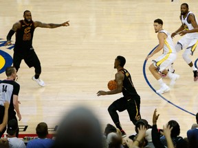 J.R. Smith of the Cleveland Cavaliers dribbles in the closing seconds of regulation as teammate LeBron James attempts direct the offence against the Golden State Warriors  in Game 1 of the NBA Finals on Wednesday night in Oakland.