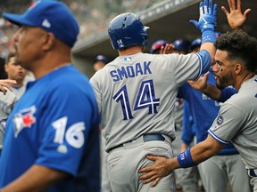 In this June 3 file photo, Toronto Blue Jays players celebrate Justin Smoak's home run against the Detroit Tigers.