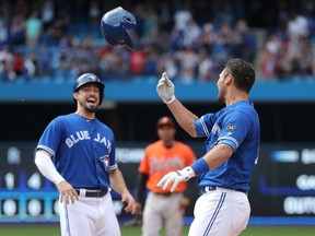 Luke Maile of the Blue Jays is congratulated by Randal Grichuk  after drawing a bases-loaded RBI walk to drive in the game-winning run in the tenth inning during game  against the Baltimore Orioles at Rogers Centre on Saturday in Toronto.