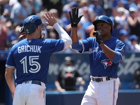 Curtis Granderson #18 of the Toronto Blue Jays is congratulated by Randal Grichuk #15 after hitting a three-run home run in the fourth inning during MLB game action against the Baltimore Orioles at Rogers Centre on June 10, 2018 in Toronto, Canada.