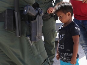 A boy and father from Honduras are taken into custody by U.S. Border Patrol agents near the U.S.-Mexico Border on June 12, 2018 near Mission, Texas.