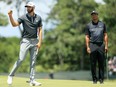 Dustin Johnson celebrates making a birdie on the seventh hole as Tiger Woods looks on during the second round of the U.S. Open on Friday at Shinnecock Hills Golf Club in Southampton, N.Y.