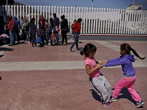 Migrants wait for asylum hearings while kids play outside of the port of entry in Tijuana, Mexico on Monday, June 18, 2018.