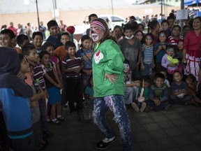 A clown performs for children who survived to the Volcan de Fuego or "Volcano of Fire" eruption near a shelter in Alotenango, Guatemala, Thursday, June 7, 2018. Guatemalan prosecutors ordered an investigation into whether emergency protocols were followed properly, as many residents were caught by the eruption with little or no time to evacuate.