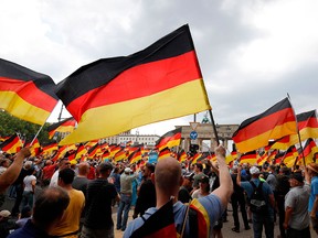 Alternative for Germany (AfD) demonstrators wave German flags in front of the Brandenburg Gate in Berlin during a "demonstration for the future of Germany" called by the far-right party on May 27, 2018.