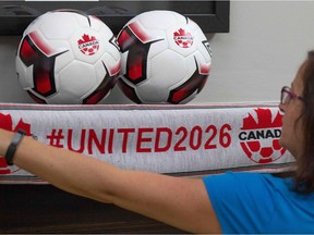 An employee holds up a scarf with the hashtag for the North American 2026 World Cup bid at Soccer Canada Headquarters in Ottawa on June 13.