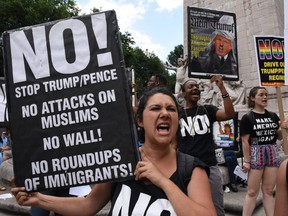 In this file photo taken on June 26, 2017 protesters with 'Today Refuse Fascism' hoist signs at Columbus Circle in New York City prior to a march to Trump Tower to denounce the Supreme Court's reinstatement of large parts of the Trump/Pence travel ban. The Supreme Court on June 26, 2018 upheld Trump's controversial ban on travellers from five mostly Muslim countries.