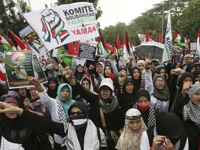 Muslim protesters shout slogans during a pro-Palestinian rally marking the International Al-Quds (Jerusalem) Day outside the U.S. Embassy in Jakarta, Indonesia, Friday, June 8, 2018. Al-Quds Day which was declared by the late Iranian spiritual leader Ayatollah Ruhollah Khomeini in 1979 as an international day of struggle against Israel and for the liberation of Jerusalem is observed every last Friday of the Muslim holy month of Ramadan.