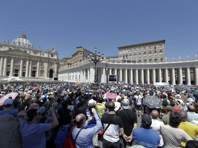 People watch Pope Francis as he recites the Angelus noon prayer from the window of his studio overlooking St. Peter's Square, at the Vatican, Sunday, June 10, 2018.