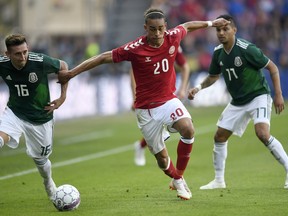 Denmark's Yussuf Yurary Poulsen, centre vies for the ball with Mexico's Hector Herrera and Jesus Manuel Corona,  during the friendly soccer match between Denmark and Mexico at Brondby Stadium, in Brondby,  Denmark, Saturday, June 9, 2018.