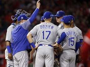 Kansas City Royals manager Ned Yost raises his arm to make a pitching change, removing starter Brad Keller, third from right, during the fifth inning of the team's baseball game against the Los Angeles Angels in Anaheim, Calif., Tuesday, June 5, 2018.