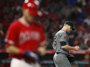 Arizona Diamondbacks starting pitcher Matt Koch, right, looks at the ball after hitting Los Angeles Angels' Ian Kinsler with a pitch during the fifth inning of a baseball game Tuesday, June 19, 2018, in Anaheim, Calif.