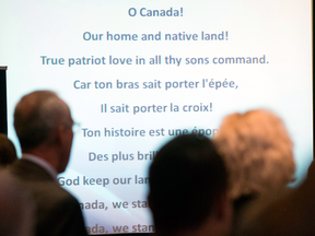 The words to O Canada are projected on a screen during a national Conservative caucus in Victoria, B.C. In its French version the anthem contains Christian imagery and invokes “valour steeped in faith.”