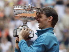 Spain's Rafael Nadal lifts the trophy as he celebrates winning the men's final match of the French Open tennis tournament against Austria's Dominic Thiem in three sets 6-4, 6-3, 6-2, at the Roland Garros stadium in Paris, France, Sunday, June 10, 2018.