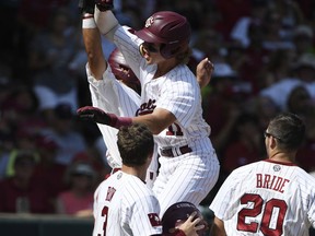 South Carolina's LT Tolbert (11) celebrates with teammates after hitting a grand slam home run against Arkansas in the fifth inning of an NCAA college baseball tournament super regional baseball game in Fayetteville, Ark., Sunday, June 10, 2018.