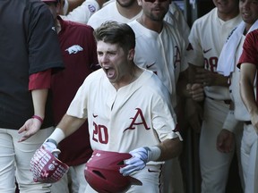 Arkansas second baseman Carson Shaddy celebrates with teammates after hitting a home run against South Carolina in the first inning of an NCAA college baseball tournament super regional baseball game in Fayetteville, Ark., Monday, June 11, 2018.