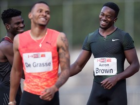 Andre De Grasse (left) smiles as Aaron Brown celebrates his first-place finish in the Canada-China challenge men's 100-metre race at the Harry Jerome International Track Classic in Burnaby, B.C., on June 26.