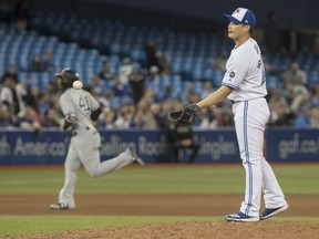 Toronto Blue Jays pitcher Seunghwan Oh takes the ball from his catcher after he gave up a grand slam home run to New York Yankees' Miguel Andujar rounding the bases behind him in the seventh inning of their American League  game in Toronto on Tuesday.