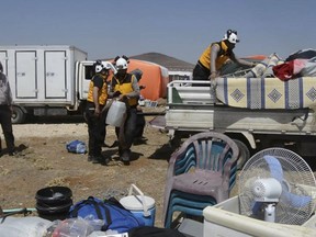 This photo released by the Syrian Civil Defense White Helmets, shows civil defense workers helping civilians who fled from Daraa after shelling by Syrian government forces, in the town of Qunaitra, near Israeli-occupied Golan Heights, southern Syria, Thursday, June 28, 2018. A barrage of airstrikes hit rebel-held areas in southwestern Syria on Thursday, killing civilians hiding in an underground shelter as government forces pressed their offensive to reclaim a region that was until recently part of a U.S.-backed and negotiated truce. (Syrian Civil Defense White Helmets via AP)