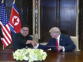 In this image made from video released by KRT on June 14, 2018, shows North Korean leader Kim Jong Un smiling at the media as he shakes hands with U.S. President Donald Trump while his sister Kim Yo Jong, left, looks on during a summit in Singapore, June 12, 2018. In the state-run media coverage of the recent summit, North Koreans are getting a new look at U.S. President Donald Trump now that his summit with leader Kim Jong Un is safely over and it's a far cry from the "dotard" label Pyongyang slapped on him last year. (KRT via AP Video)