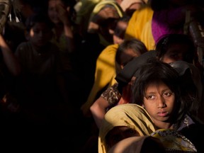 FILE - In this Jan. 27, 2018, file photo, Rohingya refugees wait in a queue to receive relief material at the Balukhali refugee camp near Cox's Bazar, Bangladesh. Myanmar and U.N. agencies signed an agreement that might eventually lead to the return of some of the 700,000 Rohingya Muslims who fled brutal persecution by the country's security forces and are now crowded into makeshift camps in Bangladesh.