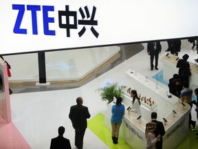 FILE - In this Wednesday, Feb. 26, 2014, file photo, people gather at the ZTE booth at the Mobile World Congress, the world's largest mobile phone trade show in Barcelona, Spain. Shares in ZTE Corp. have fallen 42 percent in Hong Kong after the Chinese telecoms equipment maker agreed to pay a $1 billion penalty to the U.S. government and replace its top managers.