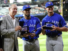 Houston Astros owner Jim Crane, left, presents 2017 World Series rings to Toronto Blue Jays outfielder Teoscar Hernandez, centre, and pitcher Tyler Clippard on June 25.