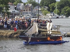 In this June 2015 photo provided by the Gaspee Days Committee, spectators watch an annual ceremonial burning of a replica of the ship HMS Gaspee in Warwick, R.I. The British customs schooner Gaspee had been sent in March 1772 to enforce maritime trade laws and prevent smuggling around Newport, R.I. In June 1772, a colonial ship lured the Gaspee through shallow waters of Narragansett Bay where it ran aground and was subsequently burned by colonists. (Gaspee Days Committee via AP)