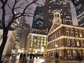 FILE - In this Feb. 22, 2007, file photo Faneuil Hall, right, sits among buildings on an evening in downtown Boston. Faneuil Hall, of the most iconic buildings in Boston, where the earliest calls for independence from Britain were sounded in the late 1700s, is named for a man who owned and traded black slaves. Now a move to rename the historic structure is gaining momentum.