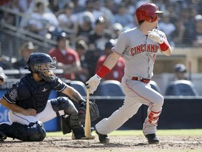 Cincinnati Reds' Scooter Gennett, right, hits an RBI single to score Jesse Winker, with San Diego Padres catcher Raffy Lopez watching, during the fifth inning of a baseball game in San Diego, Sunday, June 3, 2018.