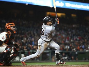 Miami Marlins' Miguel Rojas swings for an RBI single off San Francisco Giants' Hunter Strickland in the ninth inning of a baseball game Monday, June 18, 2018, in San Francisco.