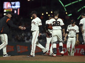 San Francisco Giants manager Bruce Bochy, left, relieves pitcher Hunter Strickland in the ninth inning of a baseball game against the Miami Marlins Monday, June 18, 2018, in San Francisco.