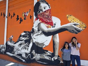 In this Monday, Jun. 25, 2018, photo, Odilia Romero, a trilingual interpreter in English, Spanish and her native Zapotec, a language from the Mexican state of Oaxaca, left, and her friend, Bricia Lopez pose for a photo outside her Oaxacan restaurant, La Guelaguetza in Los Angeles. Romero is working to put together interpretation teams who can help attorneys and officials communicate with non-Spanish-speaking indigenous children and their detained parents in an effort to ensure their legal, medical and other needs are met and that they understand immigration proceedings.