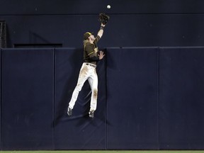 San Diego Padres center fielder Travis Jankowski can't reach a home run hit by the Cincinnati Reds' Scooter Gennett during the fifth inning of a baseball game Friday, June 1, 2018, in San Diego.