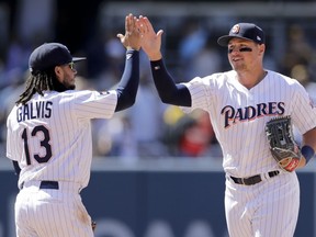 San Diego Padres shortstop Freddy Galvis (13) celebrates with teammate right fielder Hunter Renfroe after defeating the Atlanta Braves in a baseball game Wednesday, June 6, 2018, in San Diego. The Padres won 3-1.