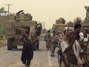 This still image taken from video provided by Arab 24 shows Saudi-led forces gathering to retake the international airport of Yemen's rebel-held port city of Hodeida from the Shiite Houthi rebels Saturday, June 16, 2018.  With battles raging at the southern side of al-Hodeida International Airport, the military of Yemen's exiled government said it had entirely seized the facility, and that engineers were working to clear mines from nearby areas just south of the city of some 600,000 people on the Red Sea.  (Arab 24 via AP)