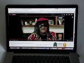 This June 22, 2018 photo, comedian Samir Ghanem wears a wig with braids on an Egyptian show called "Azmi We Ashgan," which aired on the privately owned Al-Nahar channel, is seen on a laptop. In an attempt to capitalize on what's become a ratings bonanza for Arabic satellite channels during the Muslim holy month Ramadan, two comedies struck the wrong chord with audiences when their lead actors appeared in blackface. Criticism was swift on social media, but failed to trigger a wider discussion on racism in Arab media.