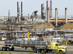 This March 9, 2010, file photo shows a tanker truck passing the Chevron oil refinery in Richmond, Calif. A U.S. judge who held a hearing about climate change that received widespread attention has thrown out the underlying lawsuits that sought to hold big oil companies liable for the role of fossil fuels in the Earth's warming environment.