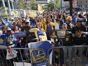 Fans wait for the parade to start in honor of the Golden State Warriors, Tuesday, June 12, 2018, in Oakland, Calif., to celebrate the team's NBA basketball championship.