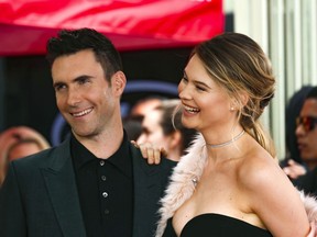 FILE - In this Feb. 10, 2017, file photo, Adam Levine, left, and his wife Behati Prinsloo smile at a ceremony that honored him with a Star on the Hollywood Walk of Fame in Los Angeles. Maroon 5 singer Levine spent his first Father's Day as a dad of two. Prinsloo shared a photo on Instagram of Levine holding their second daughter Gio Grace, who was born in February.