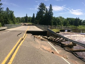 This photo provided by the Wisconsin Department of Transportation shows Wisconsin Highway 35 over Black River damaged from flash flooding in Pattison State Park in Douglas County, Wis., on Monday, June 18, 2018. The National Weather Service has since extended a flood warning through Thursday for northwestern Wisconsin and neighboring areas in Minnesota. (Wisconsin Department of Transportation via AP)