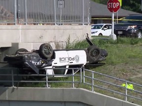 This Thursday, June 7, 2018, photo from video from WITI-TV in Milwaukee shows a squad car after it rolled over near an overpass during a high-speed chase with a motorist who had been driving recklessly in Milwaukee. The department's chief said Friday, June 8, 2018, that a Milwaukee police officer died and his partner was injured in the crash.